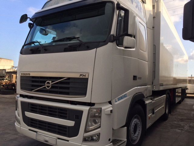 Un camión semirremolque Volvo blanco está estacionado en un estacionamiento.