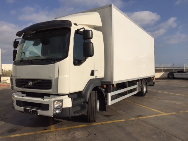 Un camión Volvo blanco está estacionado en un estacionamiento.