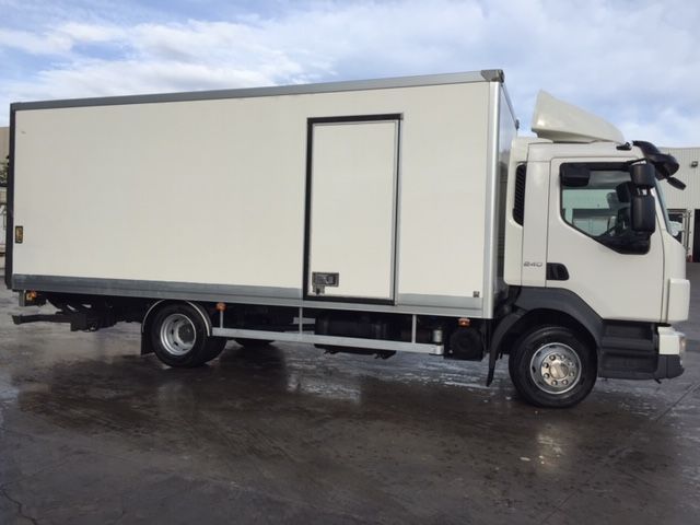 Un camión de caja blanca está estacionado en un estacionamiento.
