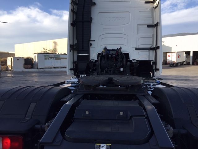 Un camión semirremolque blanco está estacionado en un estacionamiento.