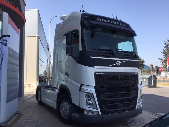 Un camión semirremolque Volvo está estacionado frente a un edificio.