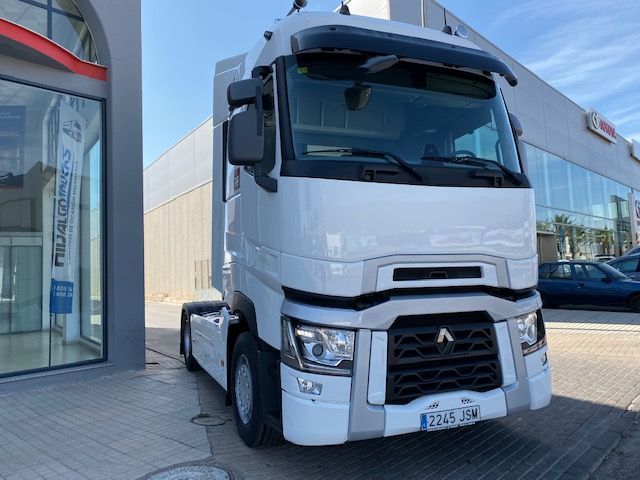 Un camión blanco está estacionado frente a un edificio.