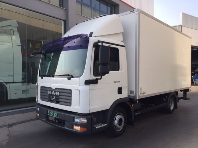 Un camión de un hombre blanco está estacionado frente a un edificio.