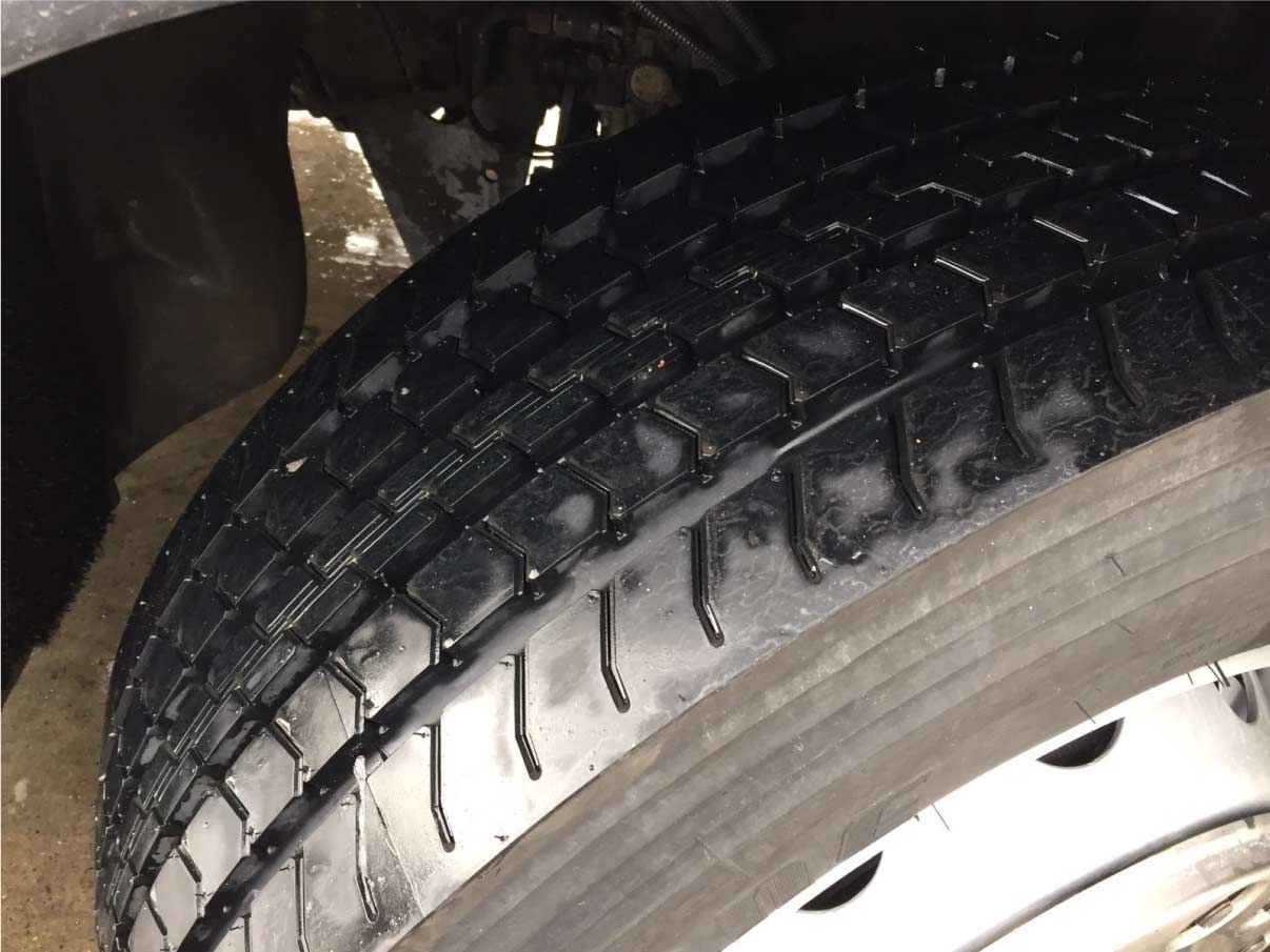 Un primer plano de un neumático con una llanta blanca.