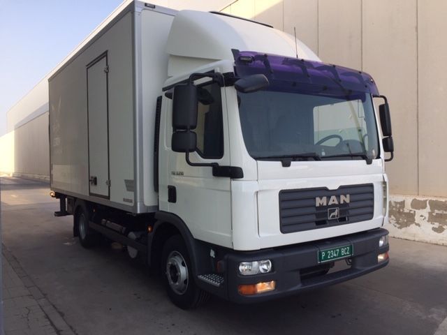 Un camión de un hombre blanco está estacionado frente a un edificio.