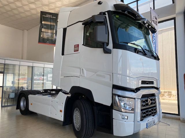 Un camión semirremolque blanco está estacionado en una sala de exposición.