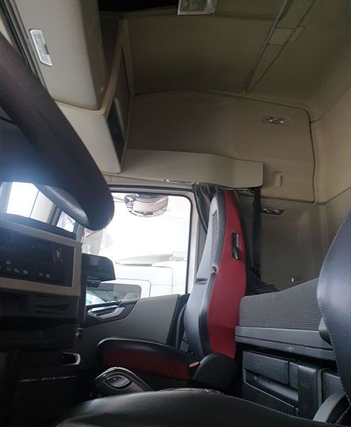 El interior de un camión con un asiento rojo y un asiento negro.
