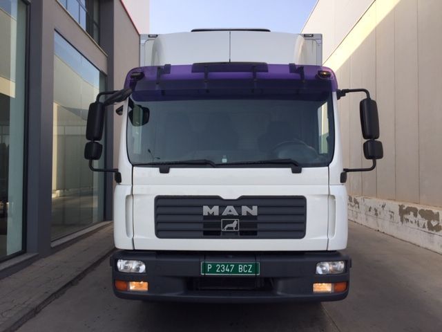 Un camión de carga está estacionado frente a un edificio.