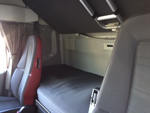 El interior de un camión con cama y asientos.