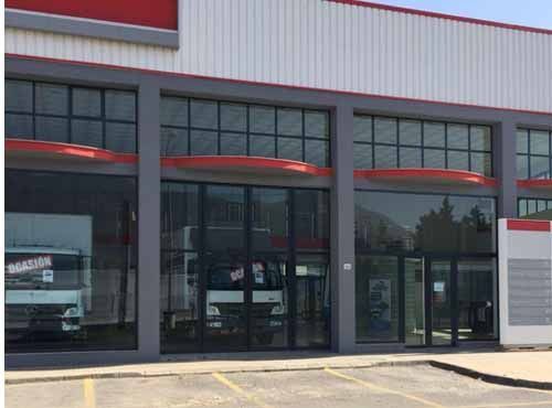 Un edificio grande con muchas ventanas y un camión estacionado frente a él.