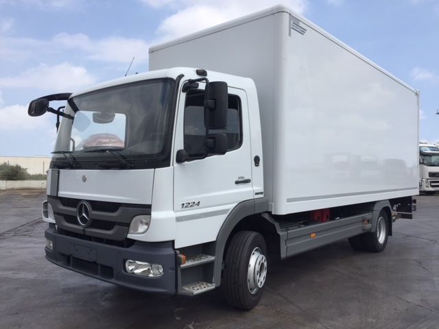 Una camioneta Mercedes blanca está estacionada en un estacionamiento.