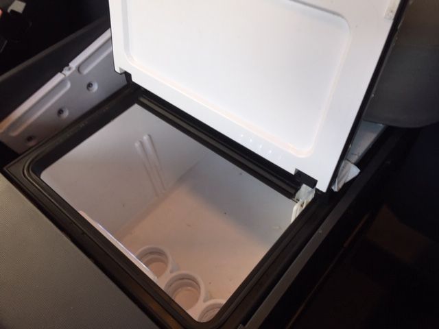 Una hielera con la tapa abierta y algunos cubitos de hielo dentro.