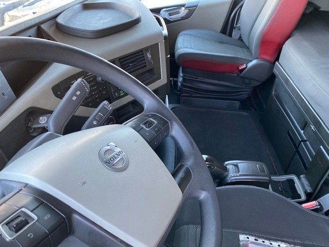 El interior de un camión Volvo con volante y asientos.