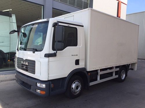 Un camión de un hombre blanco está estacionado frente a un edificio.