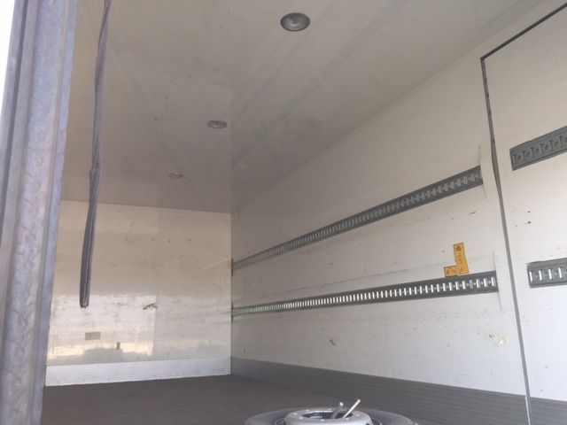 El interior de un camión vacío con la puerta abierta.