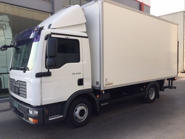 Un camión blanco está estacionado frente a un edificio.
