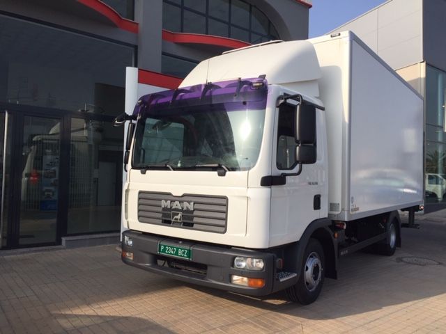 Un camión de un hombre blanco está estacionado frente a un edificio.