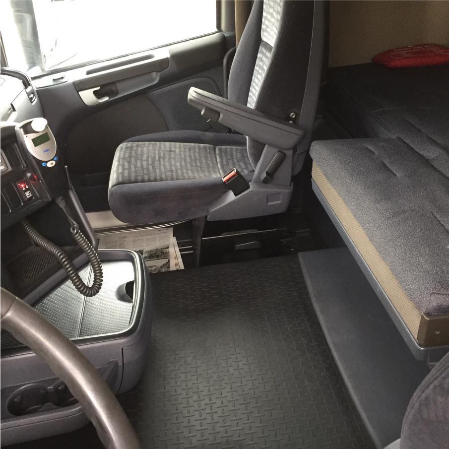 El interior de un camión con una caja y un volante.