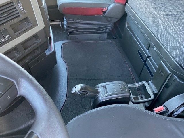 El interior de un camión con volante y asientos.