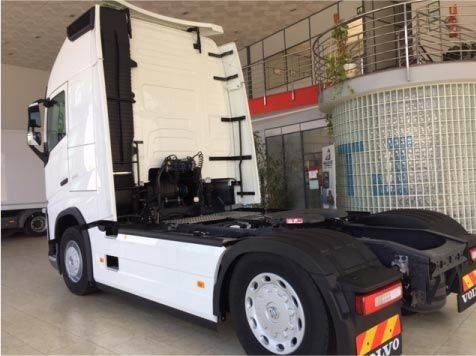 Un camión semirremolque blanco está estacionado en una sala de exposición.