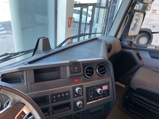 El interior de un camión con volante y tablero de instrumentos.