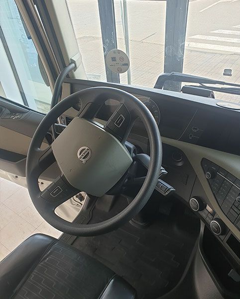 El interior de un camión con volante y tablero.