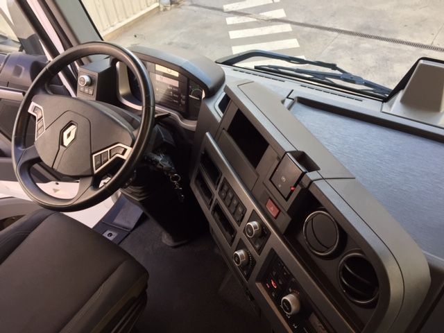 El interior de un camión con volante y tablero.