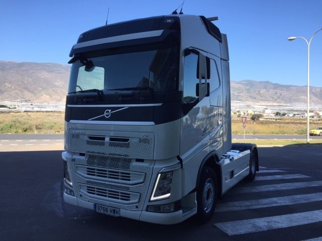 Un camión semirremolque blanco está estacionado al costado de la carretera.