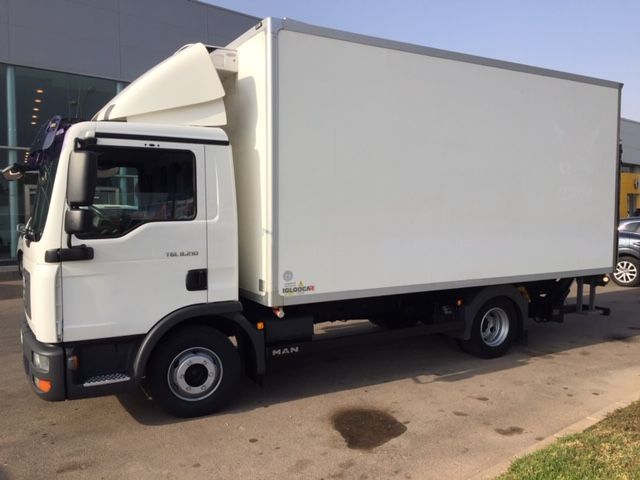 Un camión blanco está estacionado frente a un edificio.