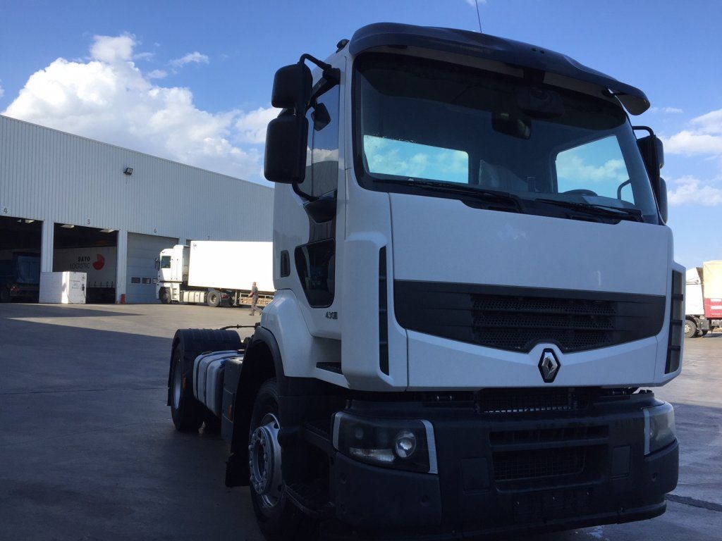 Un camión blanco está estacionado en un estacionamiento frente a un edificio.