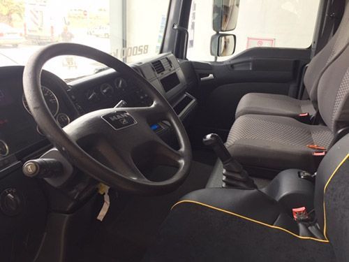 El interior de un camión con volante y asientos.