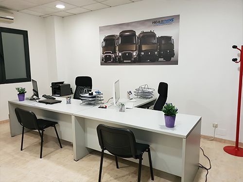 Hay una foto de camiones en la pared encima de los escritorios.