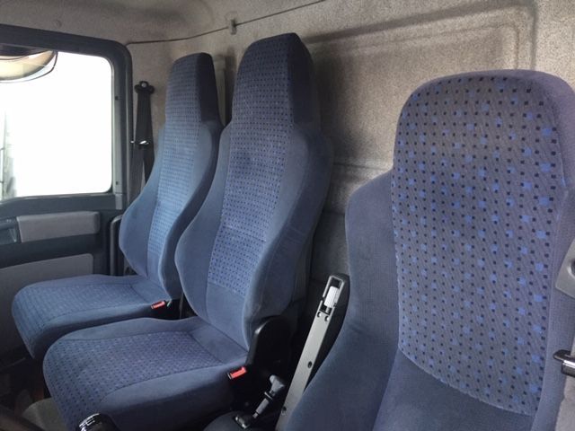 Una fila de asientos azules en la parte trasera de un camión.