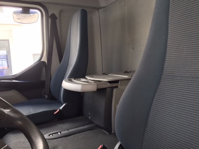 El interior de un camión con asientos azules y un volante.