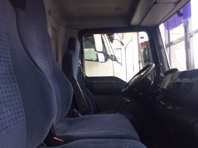 El interior de un camión con asientos azules y un volante.