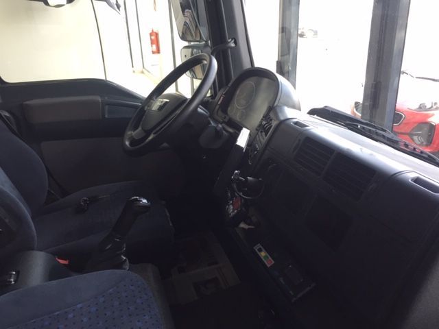 El interior de un camión con volante y asientos.