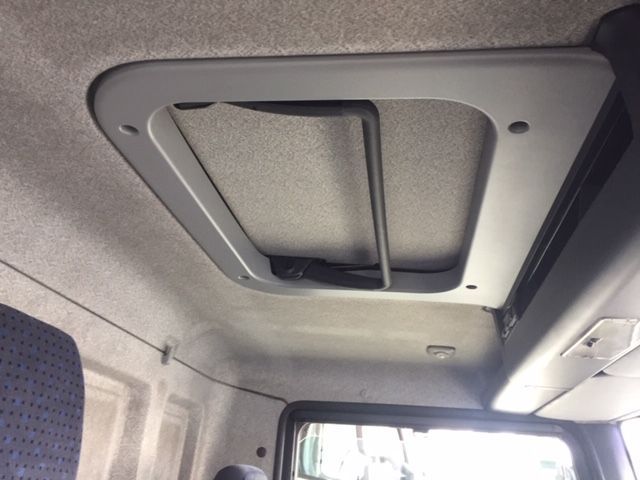 El techo de un camión tiene una ventana y un estante encima.