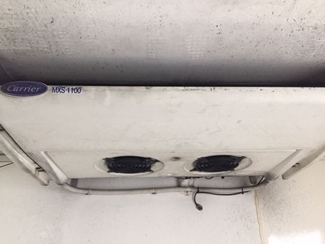 Un frigorífico transportador cuelga del techo de un edificio.