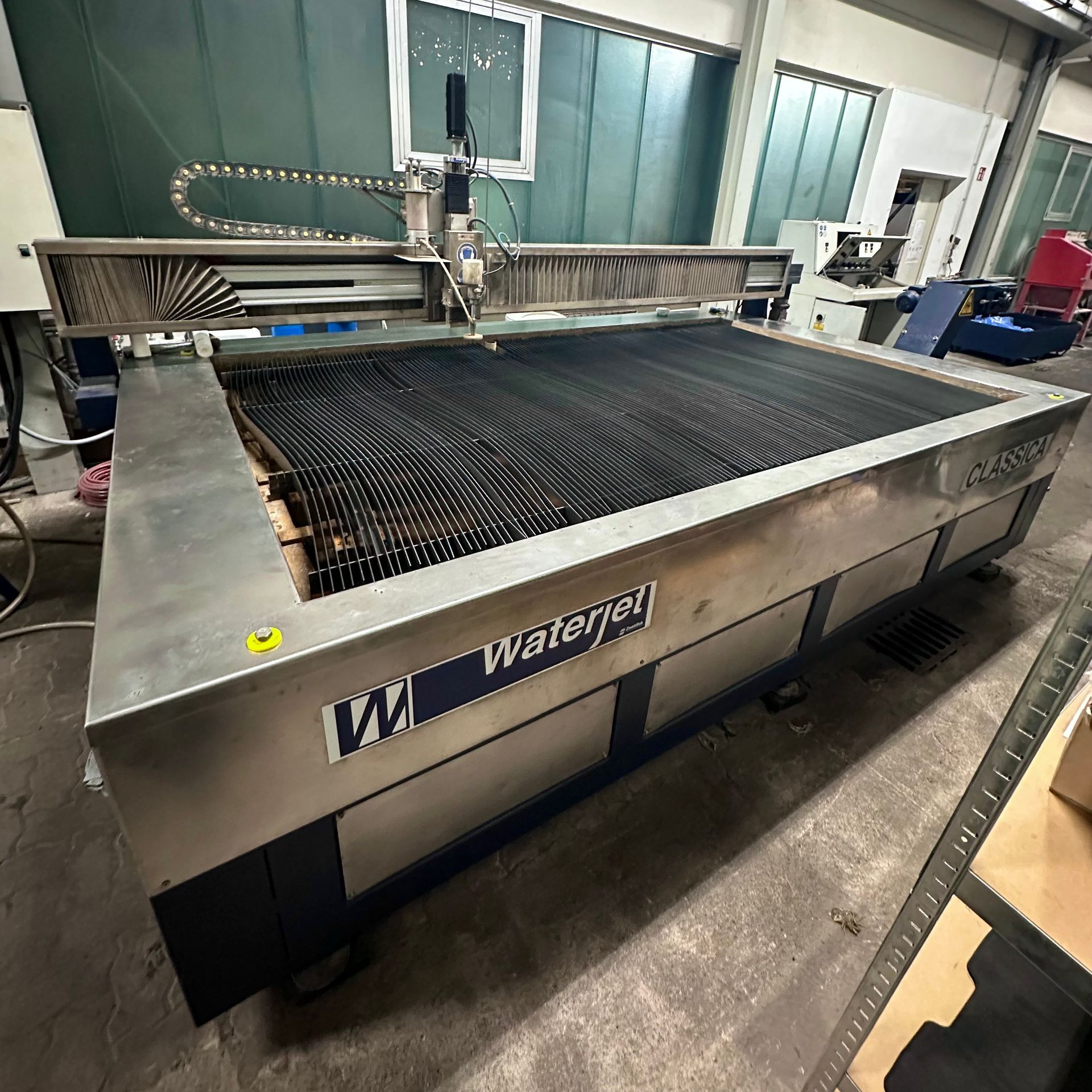 In einer Lagerhalle steht eine große Wasserstrahlmaschine.