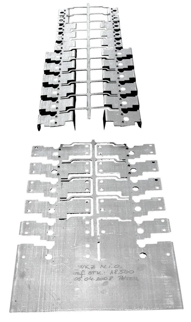 Auf einem weißen Hintergrund sind mehrere Metallteile übereinander gestapelt