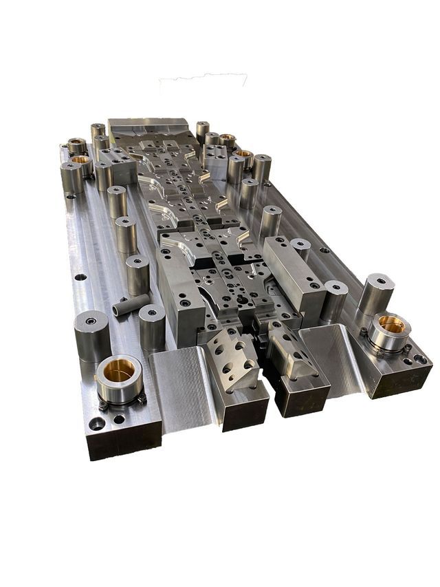 Ein Metallblock mit vielen Löchern auf weißem Hintergrund.
