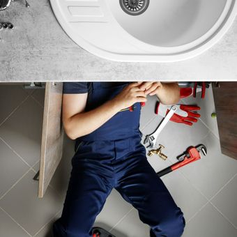 Un plombier sous une vasque