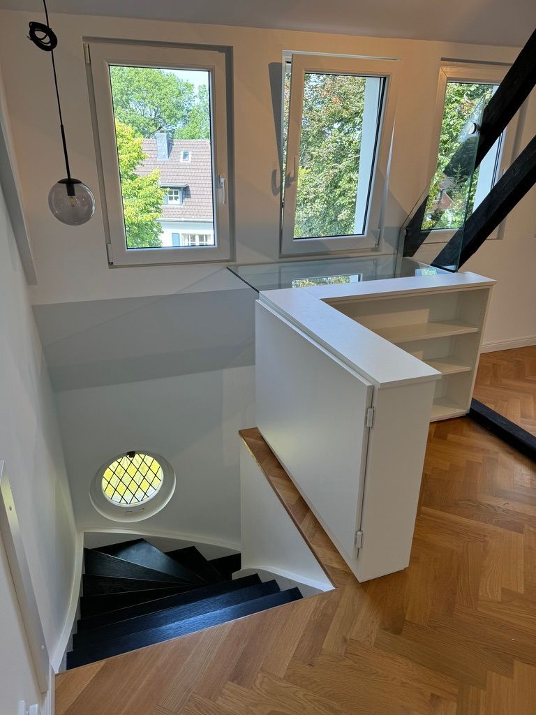 Raumgestaltung mit Treppe, Schränken, Stützbalken und halber Tür zur Treppe