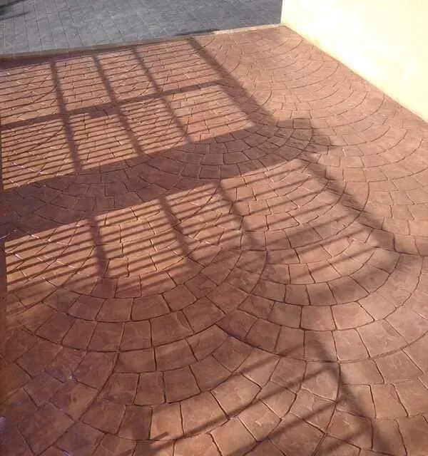 Un piso de ladrillo con una sombra de ventana sobre él.