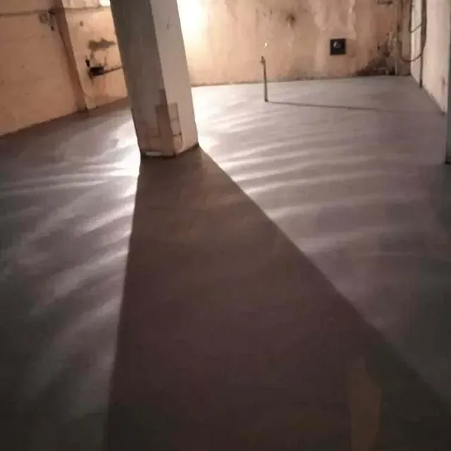 La sombra de una persona se proyecta sobre el suelo de hormigón de una habitación.