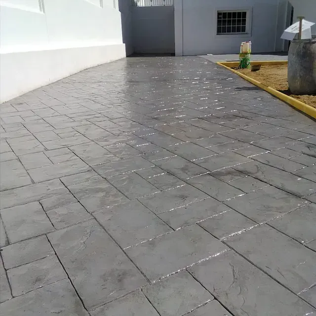 Un camino de entrada de ladrillo gris con un borde amarillo.