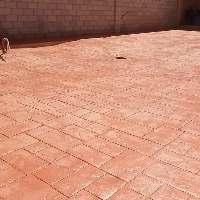 Un camino de entrada de ladrillos con una pared de ladrillos al fondo.