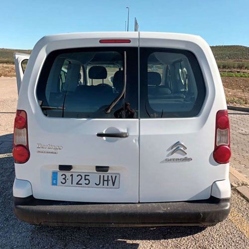Vista trasera de una furgoneta Citroën Berlingo blanca con la puerta trasera abierta, matrícula 3125 JHV.