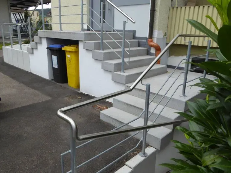 Treppe hinauf zu einem Gebäude mit einem Edelstahlgeländer