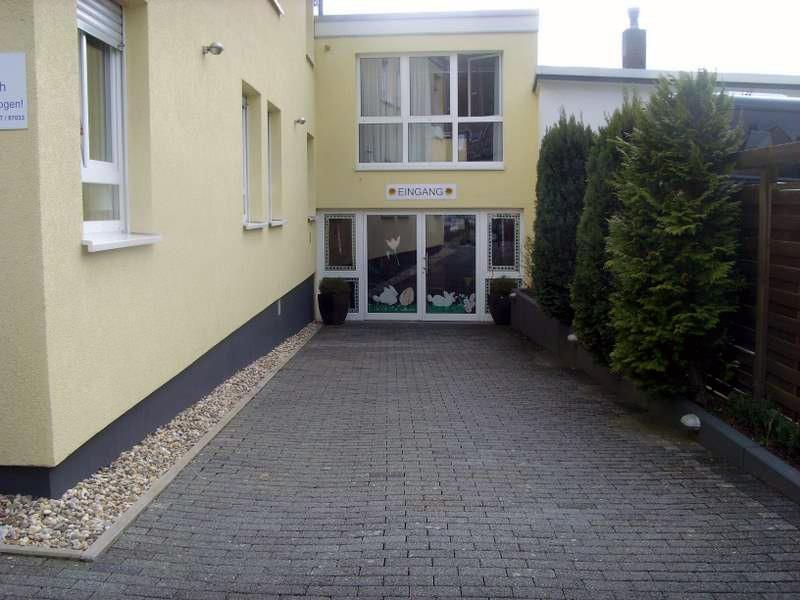 Eine gemauerte Auffahrt, die zu einem gelben Gebäude führt